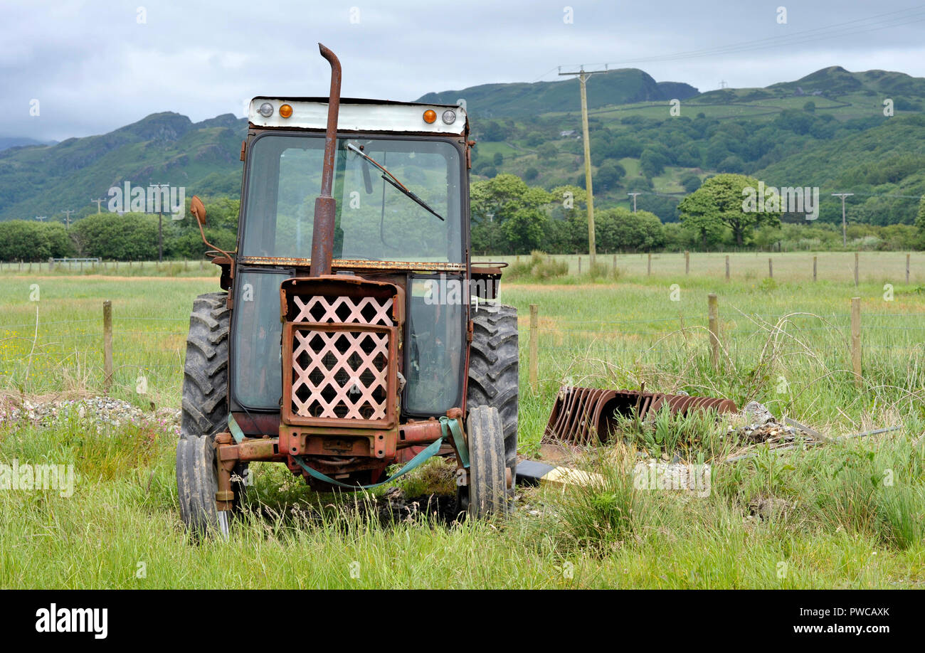 Old vintage rouille et tracteur machines agricoles dans la campagne britannique. Symbole du déclin rural et agricole. Banque D'Images