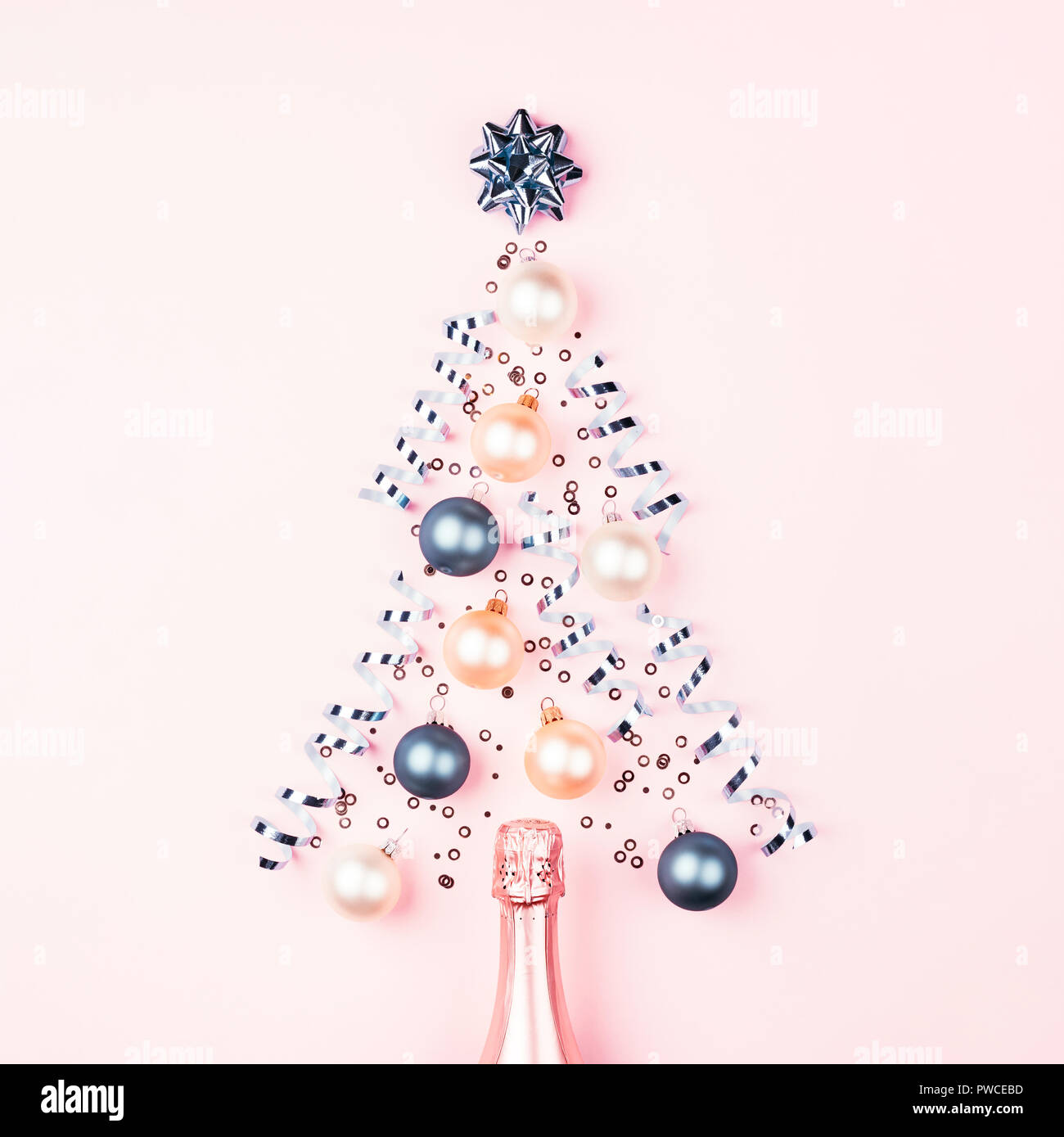 Arbre de Noël de décoration babiole sur fond rose avec du champagne. Nouveau concept de l'année minimum. Banque D'Images