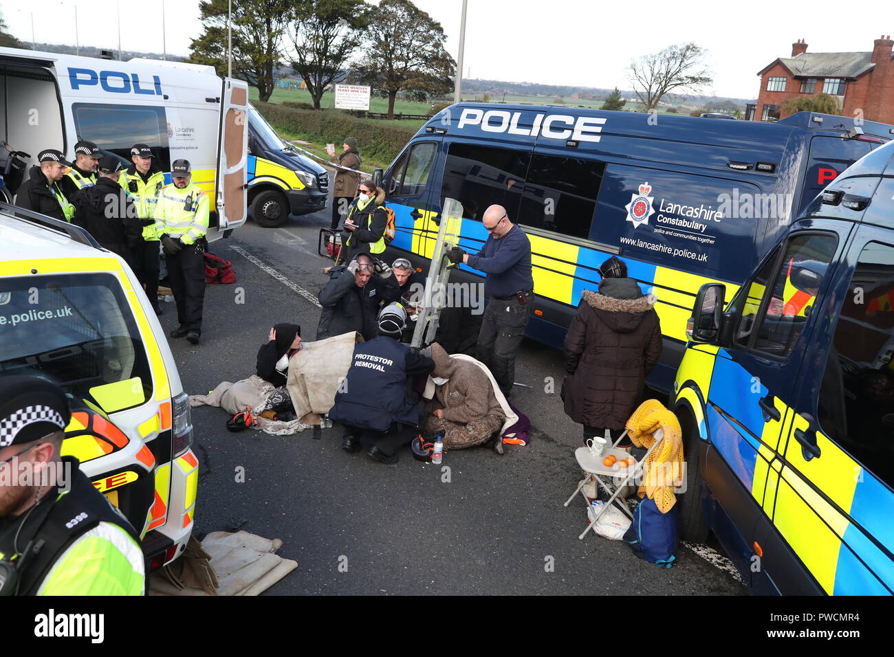 Une équipe de police a coupé un homme et une femme d'un ensemble de pneus, qu'ils avaient apparemment cimenté leurs bras sur le site de la société d'énergie extérieure Cuadrilla à Preston New Road, Little Plumpton, près de Blackpool. Les manifestants de fracking ont déclaré que leur combat venait de « prendre du sérieux », car le processus controversé devrait se poursuivre dans le Lancashire. Banque D'Images