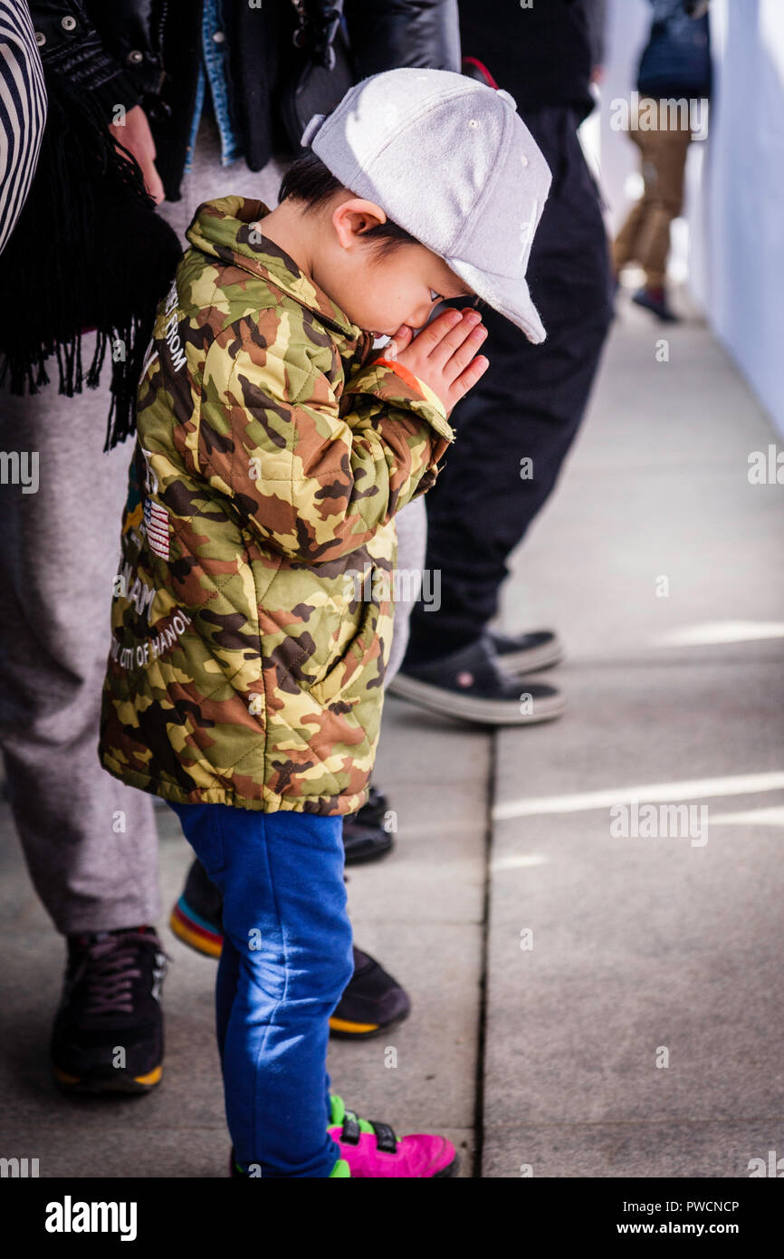 Nouvel An japonais, shogatsu. Enfant, garçon, 5-6 ans, debout priant à la peur dans le hall principal, l'Honden des Shinto Nishinomiya. Banque D'Images