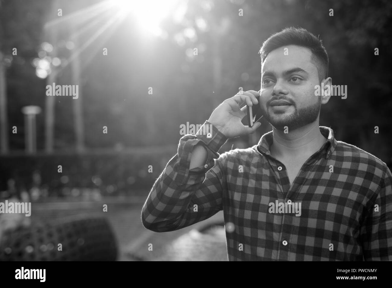 Jeune homme d'affaires indien barbu se détendre au centre commercial à Bangkok Banque D'Images