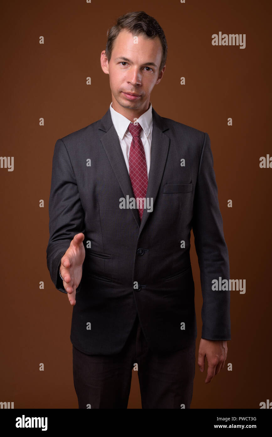 Studio shot of businessman contre fond brun Banque D'Images