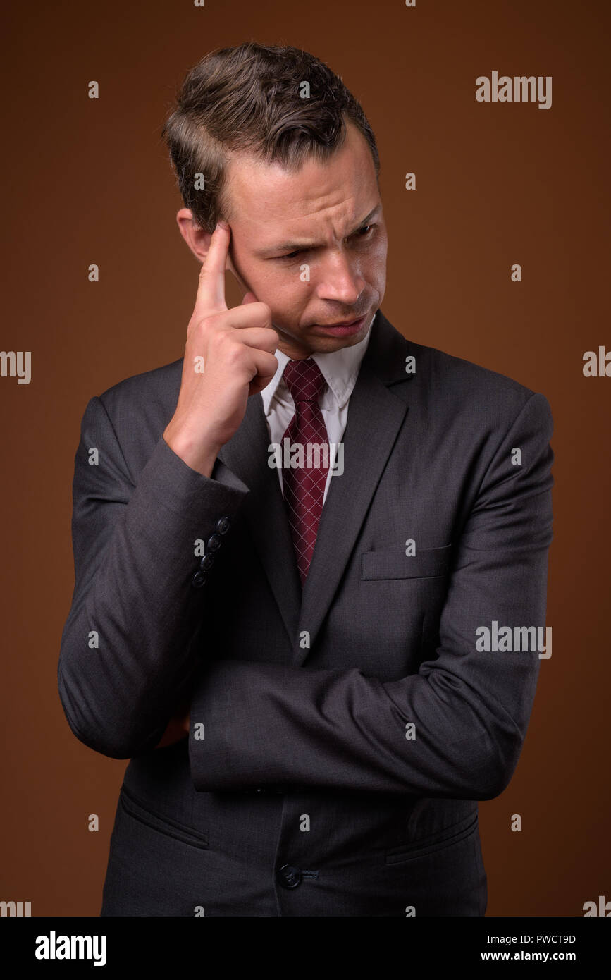 Studio shot of businessman contre fond brun Banque D'Images