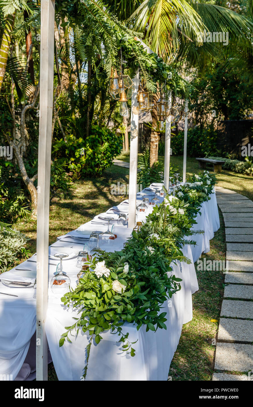 Set Table pour un dîner de mariage décorées de fleurs et de lampes en  verre. Concept d'un mariage tropical. Vertical image Photo Stock - Alamy