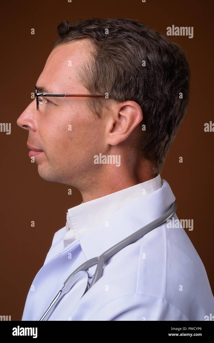 Portrait de l'homme médecin contre fond brun Banque D'Images