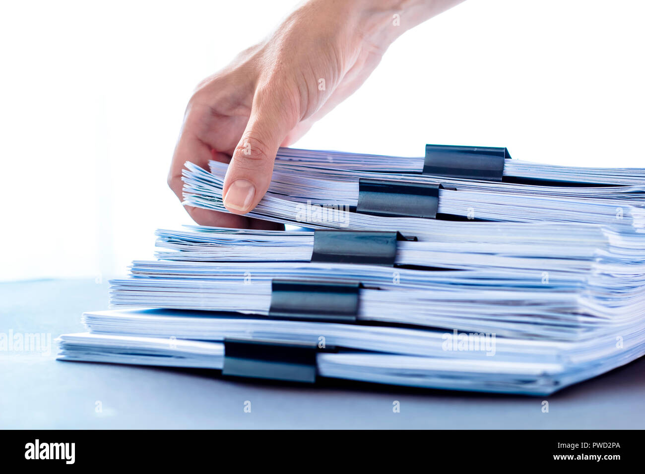 Les mains de toucher le papier de bureau. Les fichiers documents piles noir avec clip. Banque D'Images