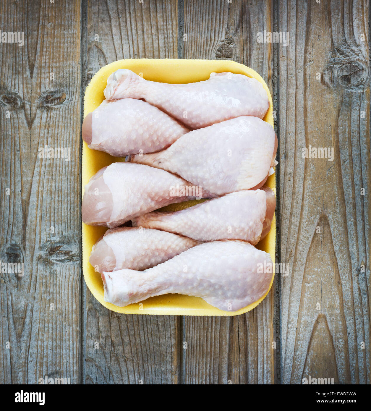 Morceaux de poulet crus frais sur un fond de bois dans un bac. Banque D'Images