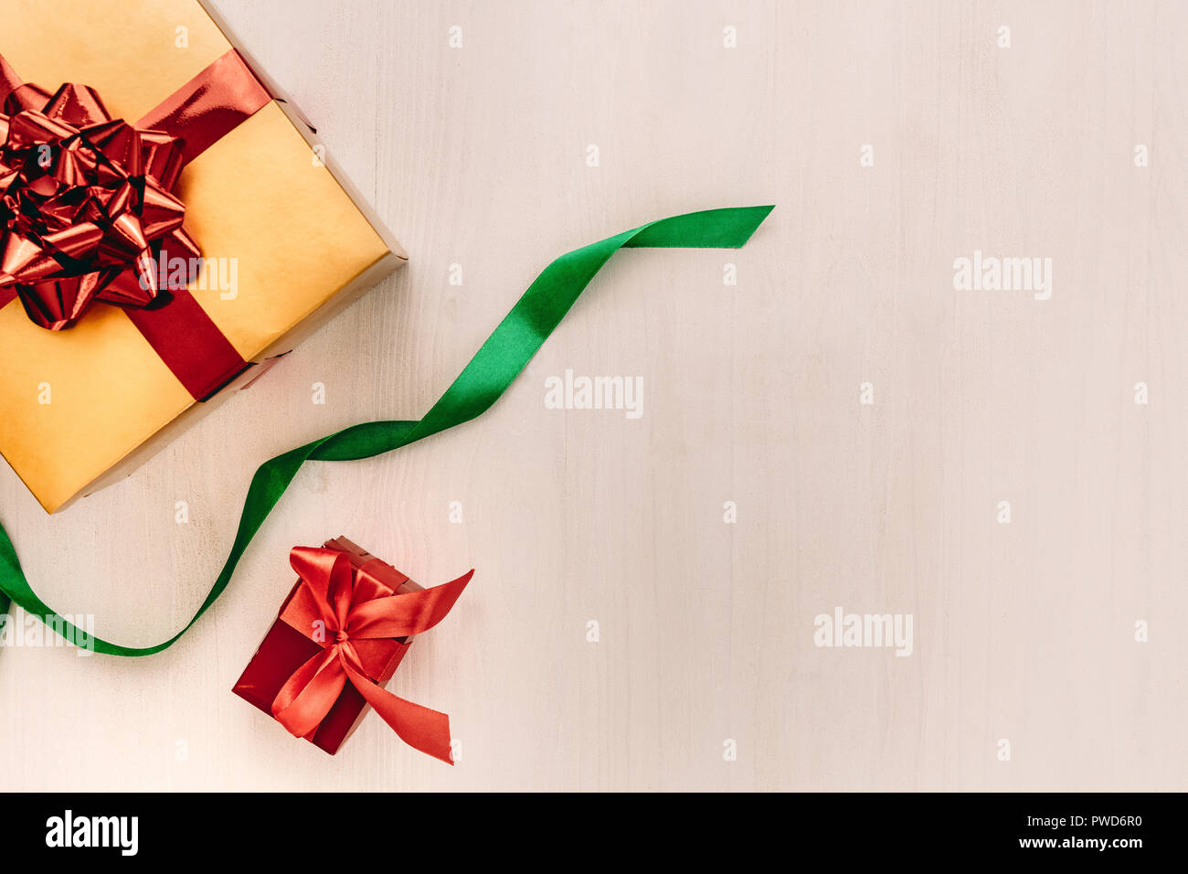 Boîtes cadeaux avec le ruban sur fond de bois. Boîtes cadeaux enveloppés de papier couleur attaché avec ruban avec copie espace sur fond beige. Concept de mise à plat. Banque D'Images