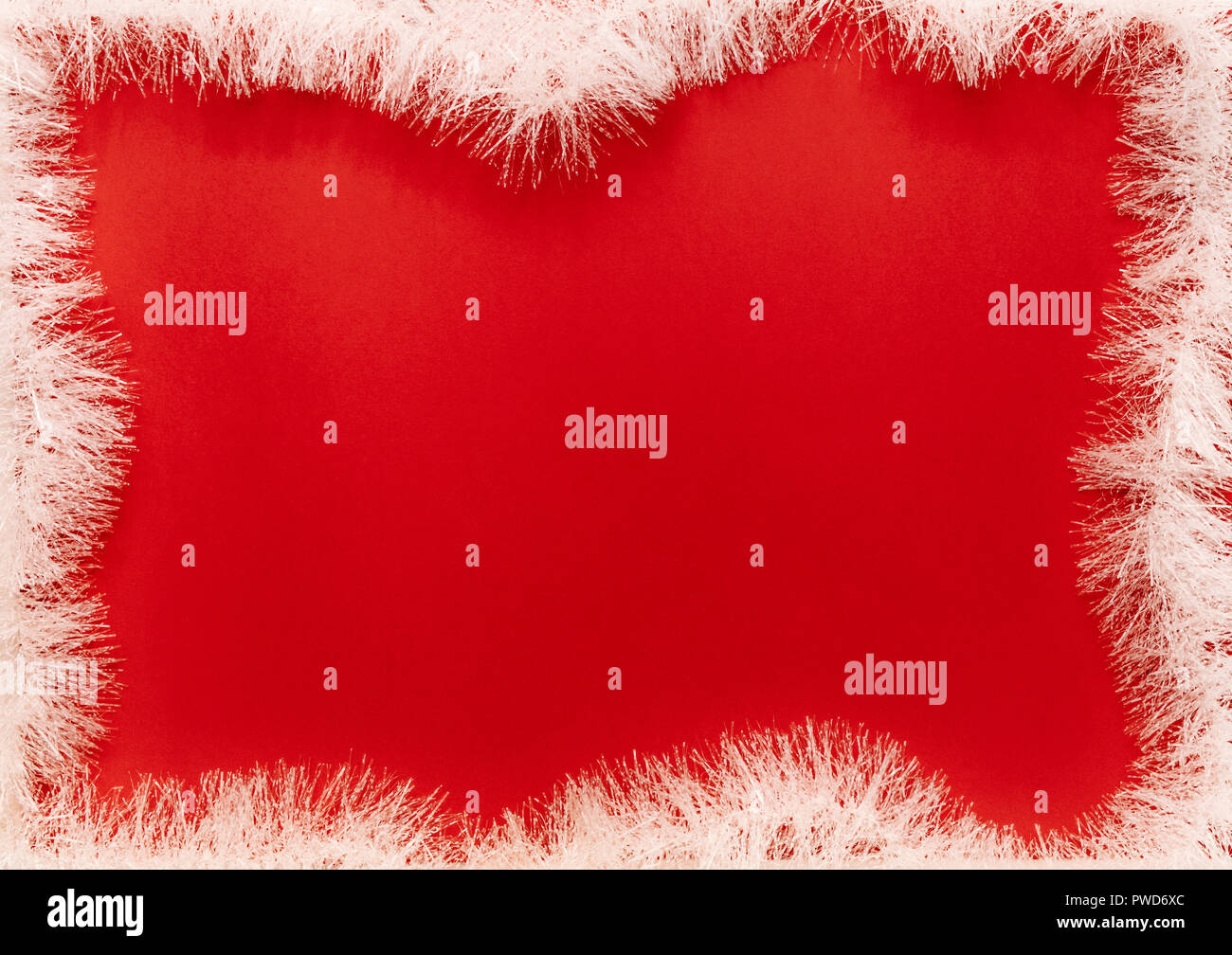 Guirlande de sapin blanc cadre sur fond rouge. Cadre de Noël avec sapin garland. Copie espace dans le centre pour votre texte. Banque D'Images