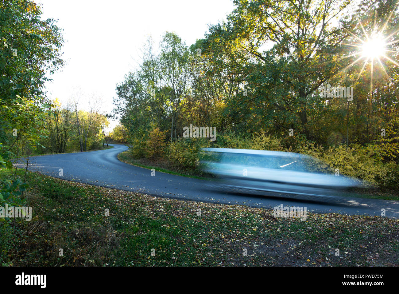Voiture roulant à travers un chemin rural en automne Banque D'Images
