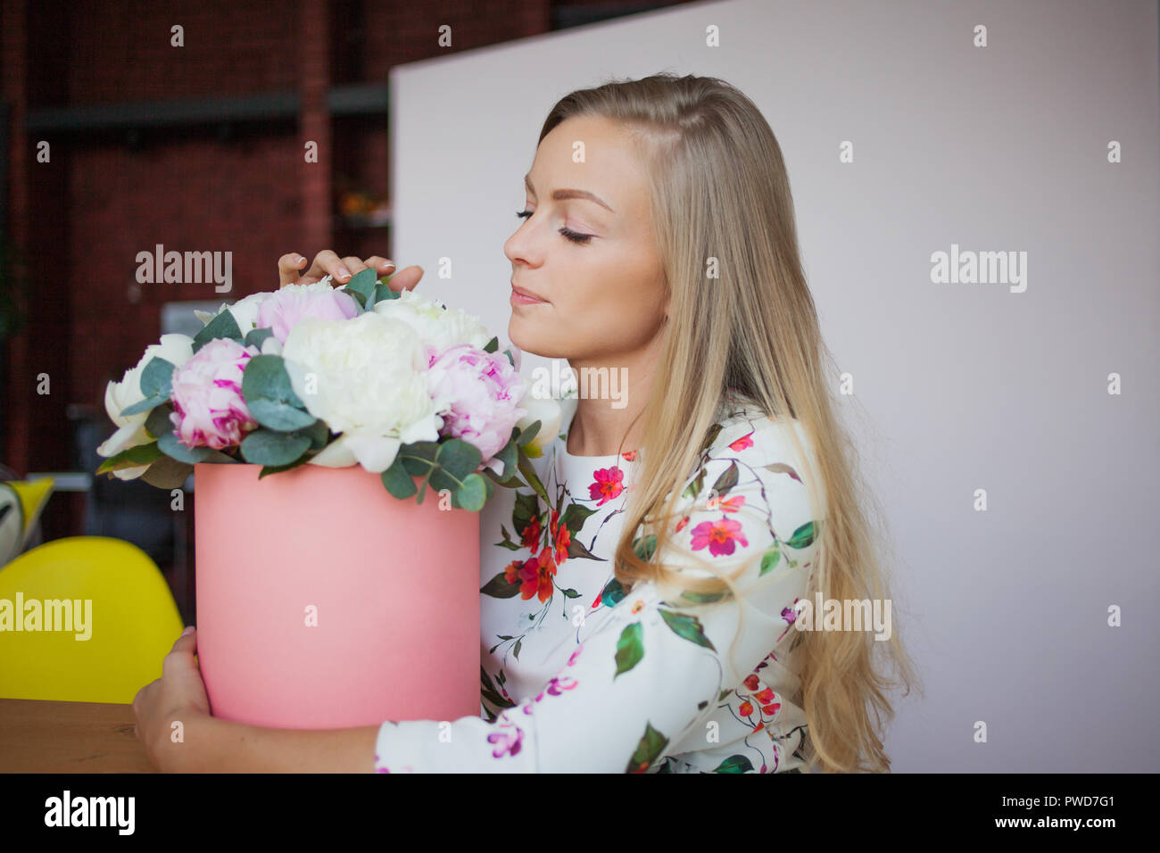 Happy Blonde Femme Dans Un Bureau Moderne Avec Des Fleurs Dans Une Boite A Chapeau Bouquet De Pivoines Livraison De Fleurs Au Milieu De Travail Photo Stock Alamy
