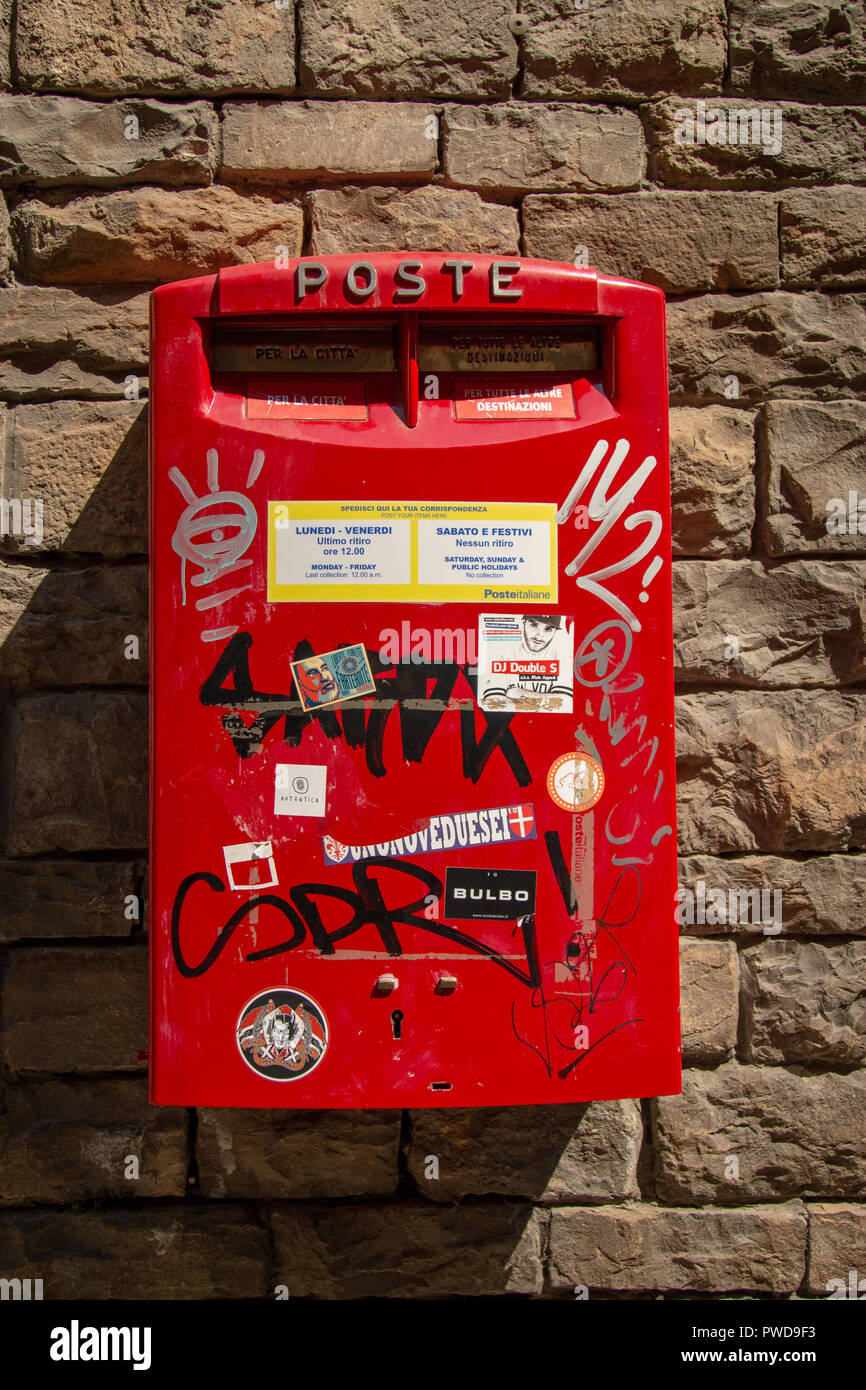 Une boîte postale rouge couverts de graffitis à Florence, Italie Banque D'Images