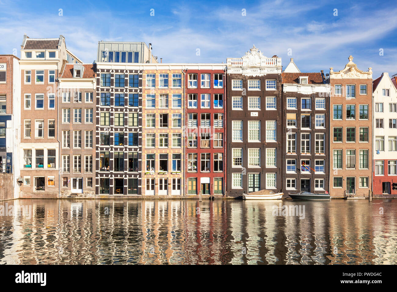 Maisons d'Amsterdam Damrak sur un canal partiellement remplies au dancing maisons avec l'architecture néerlandaise par le canal Amsterdam Hollande Pays-bas eu Europe Banque D'Images