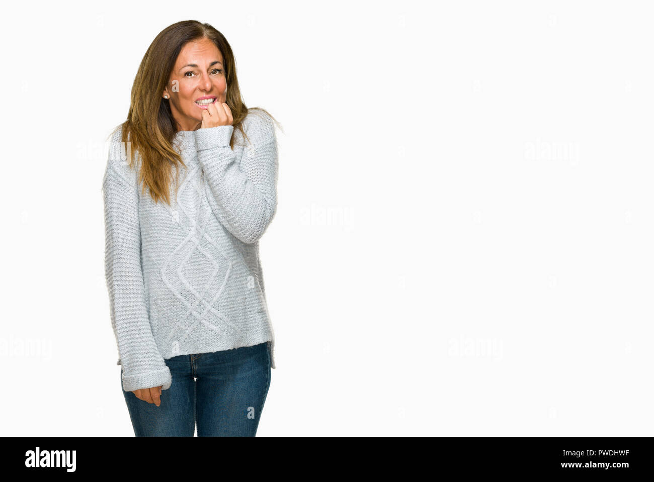Beau moyen age adult woman wearing winter sweater sur fond isolé à souligné et nerveux avec les mains sur la bouche de mordre les ongles. Anxiet Banque D'Images