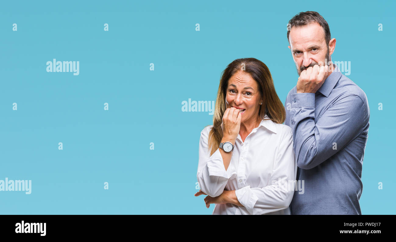 L'âge moyen hispanic business couple fond isolé à souligné et nerveux avec les mains sur la bouche de mordre les ongles. Problème d'anxiété. Banque D'Images