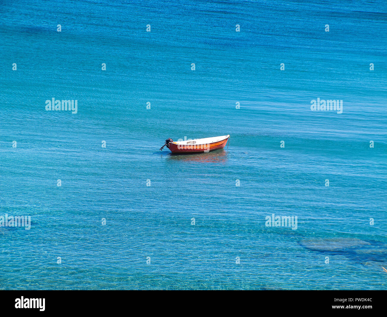 Petit bateau rouge, sans que personne à bord, au milieu de la mer bleue de la Calabre, de l'est côte italienne Banque D'Images