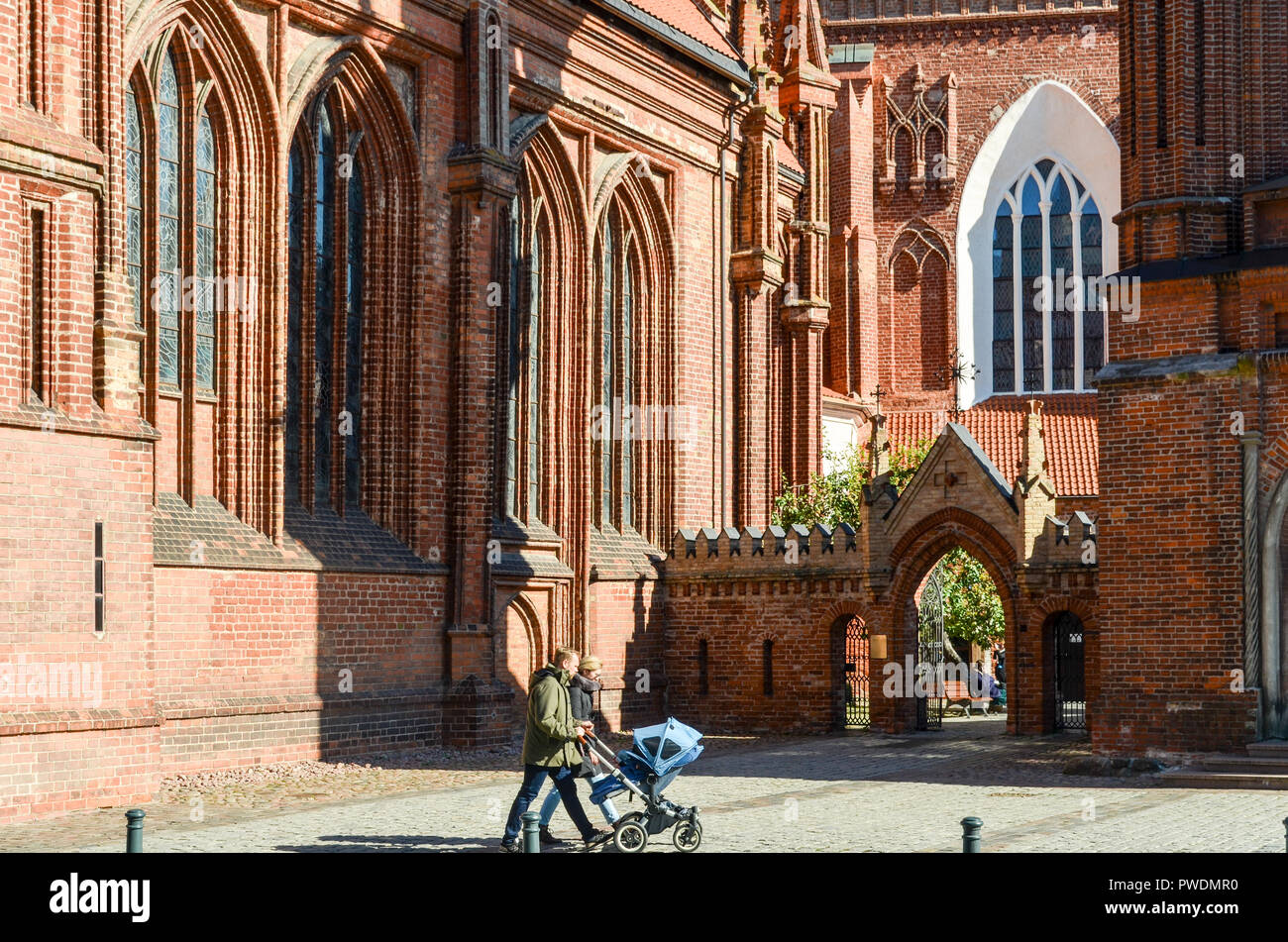 Couple avec la pram en marche avant de la Saint François d'assise (Bernardine) Église catholique romaine à Vilnius, Lituanie Banque D'Images