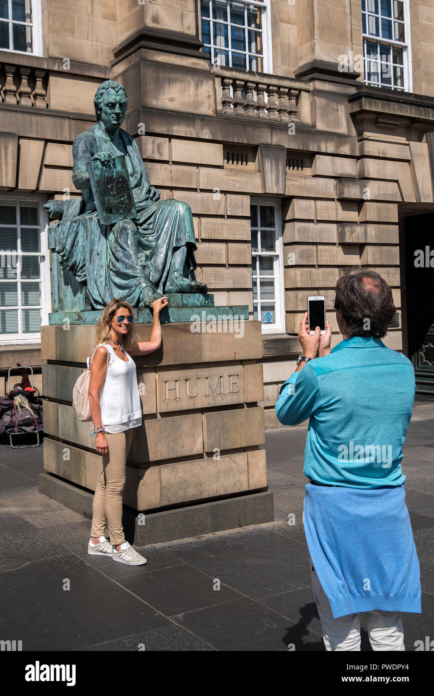Une femelle frotte touristiques la toe sur la statue de la philosophe écossais David Hume sur Edinburgh's Royal Mile. Banque D'Images