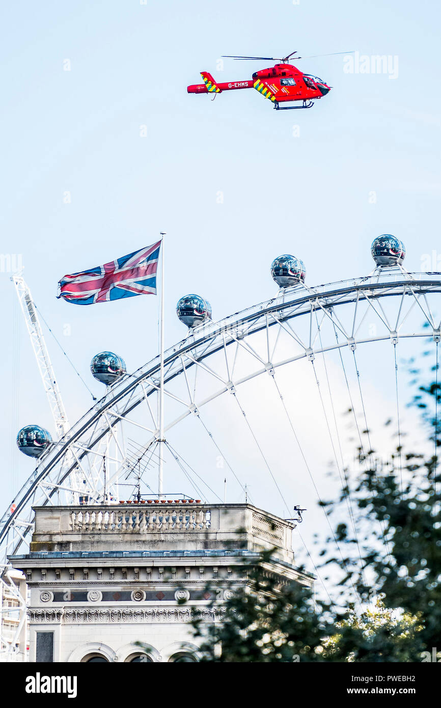 Londres, Royaume-Uni. 16 octobre, 2018. L'Air Ambulance décolle entre St James Park et Whitehall et dépasse les touristes sur le London Eye après l'accident de la route dans la région de Westminster. Crédit : Guy Bell/Alamy Live News Banque D'Images