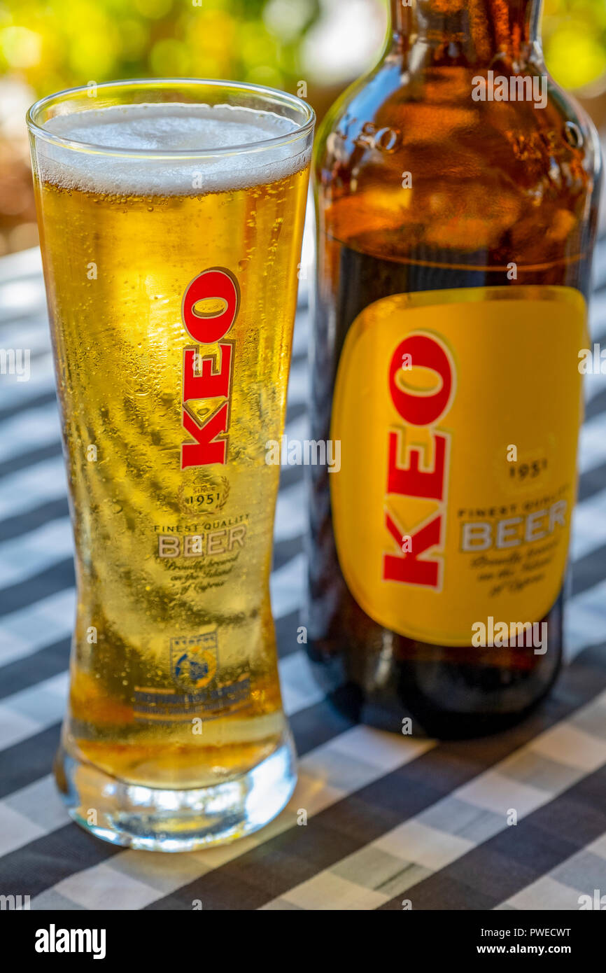 Un verre de bière Keo versé depuis une bouteille sur une table de restaurant à Kouklia village, Chypre. Banque D'Images