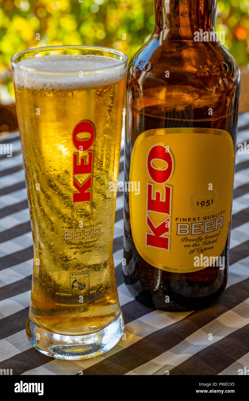 Un verre de bière Keo versé depuis une bouteille sur une table de restaurant à Kouklia village, Chypre. Banque D'Images