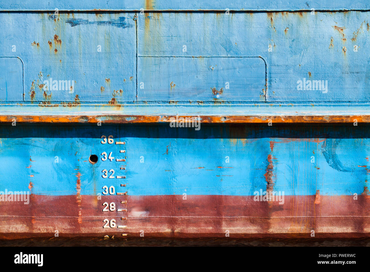 Blue cargo ship hull avec ligne de flottaison rouge et marques de tirant d'eau, texture de fond, vue de face Banque D'Images