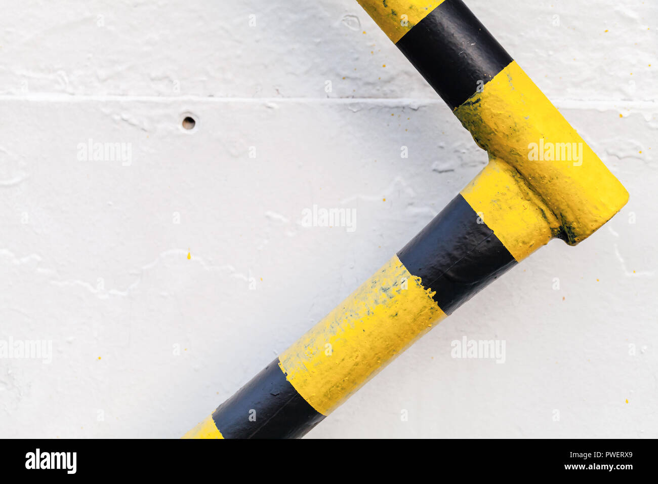 Garde-corps en métal noir jaune avec précaution sur mur blanc, fond résumé objet industriel Banque D'Images