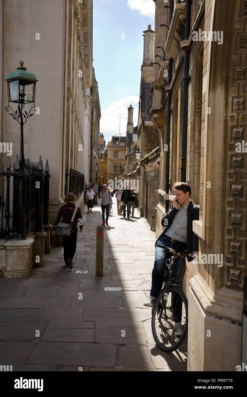 Man using mobile phone on bike, Sénat Chambre Passage, Ville de Cambridge, Cambridgeshire, Angleterre Banque D'Images