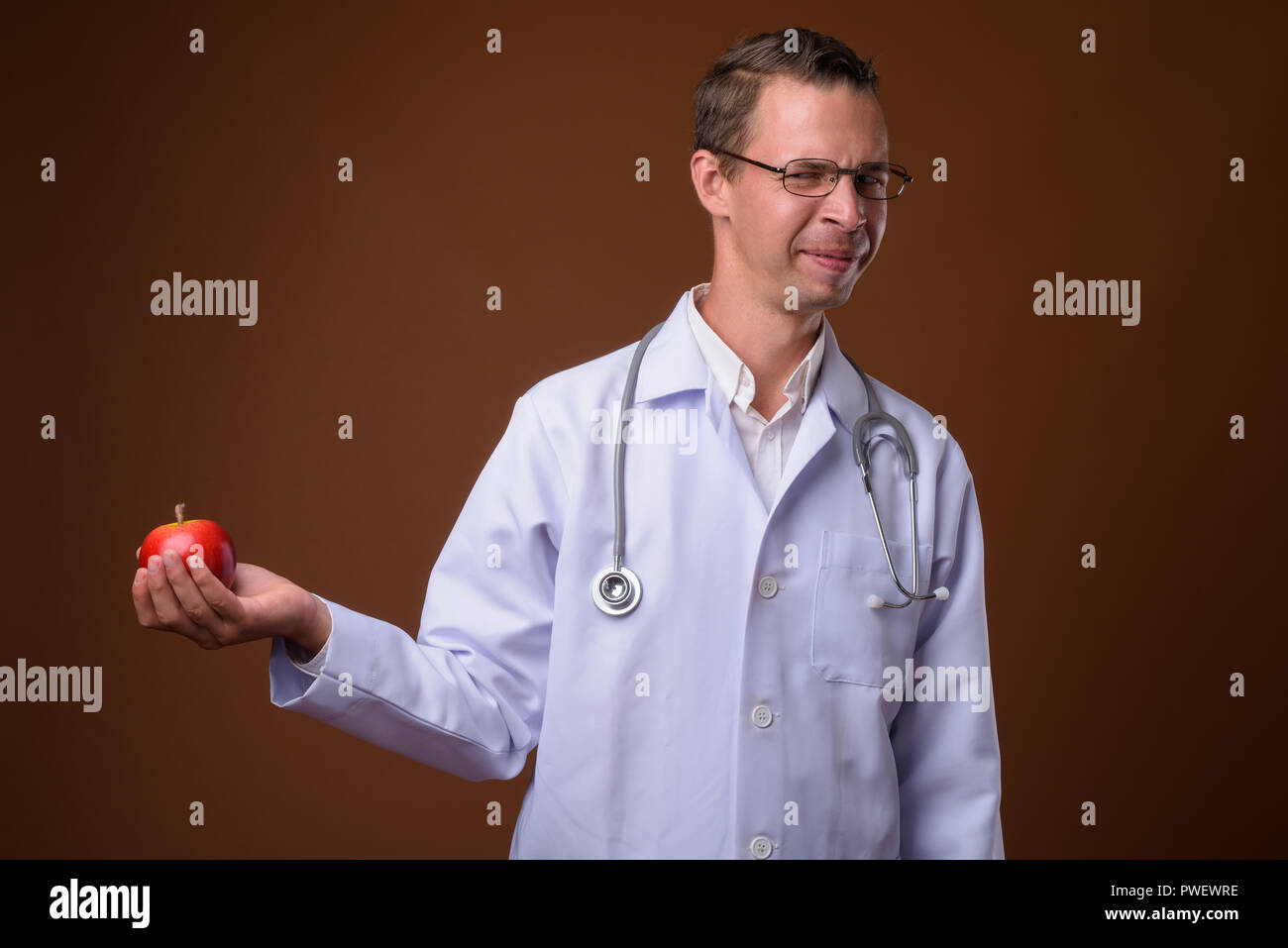 Portrait de l'homme médecin contre fond brun Banque D'Images