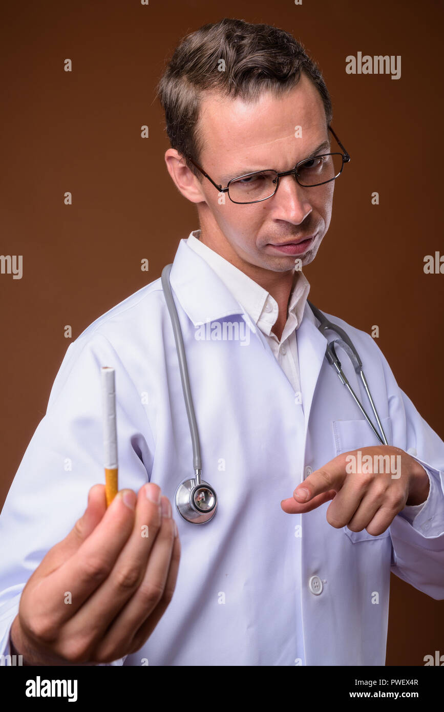 Portrait de l'homme médecin contre fond brun Banque D'Images