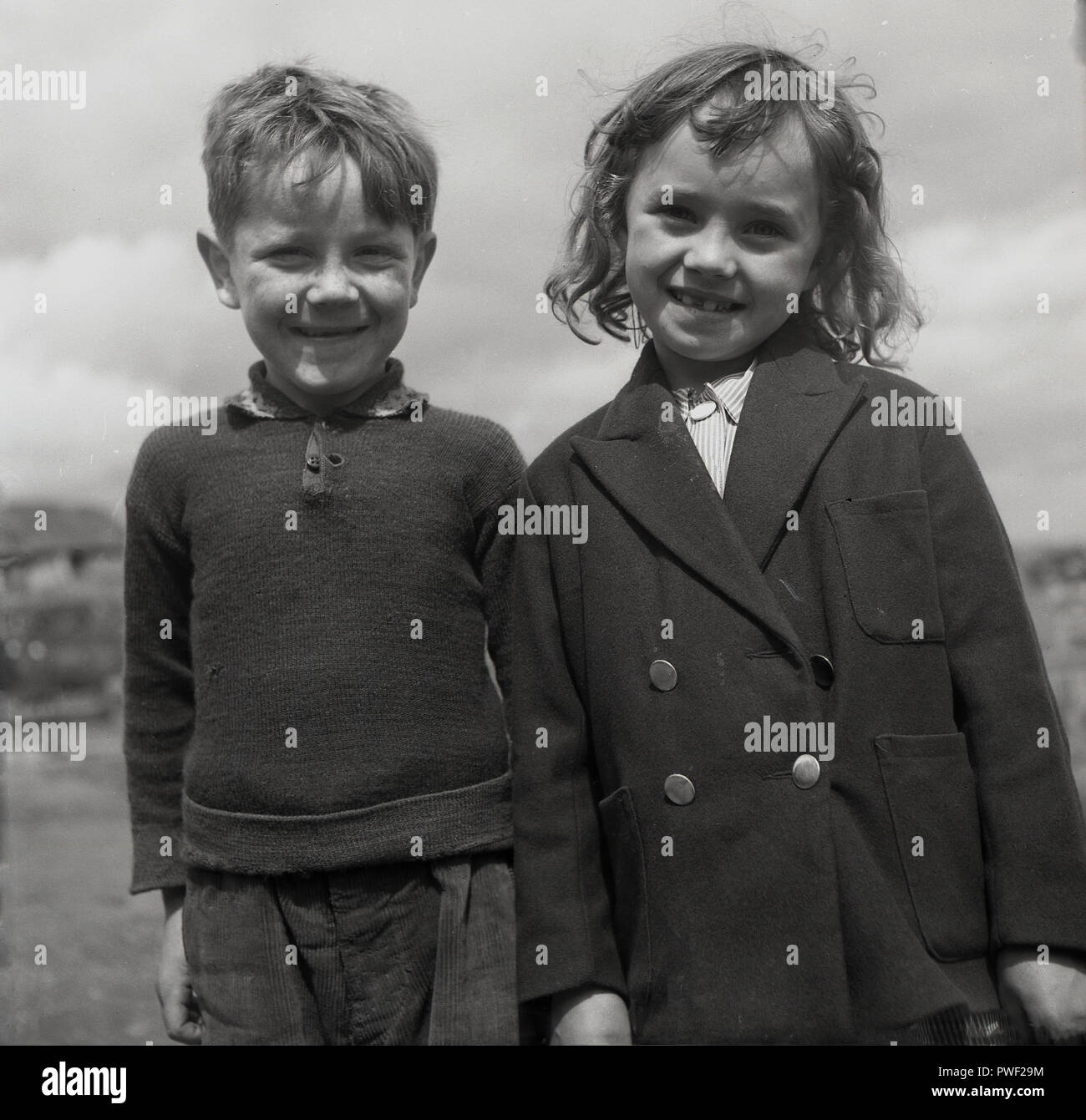 Années 1950, historique, un jeune garçon et fille irlandaise se tenir à côté de l'autre avec de grands sourires pour une photo, l'Irlande du Nord, Royaume-Uni. Banque D'Images