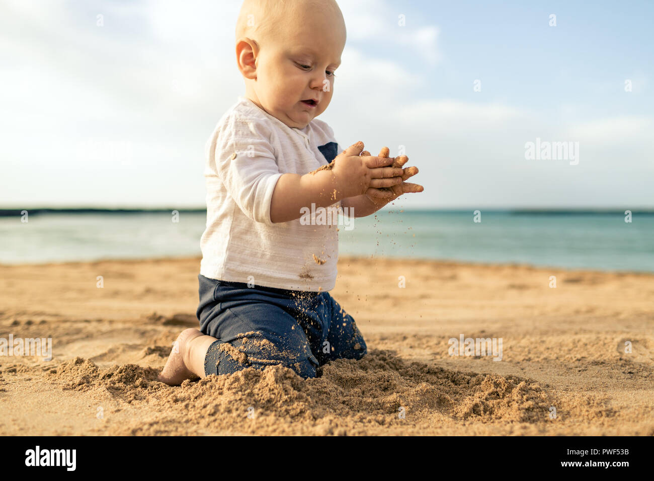 Bébé Garçon jouant sur une plage. Tout-petit de s'asseoir et de marcher sur  le sable. D'inspiration belle plage et l'océan paysage Photo Stock - Alamy