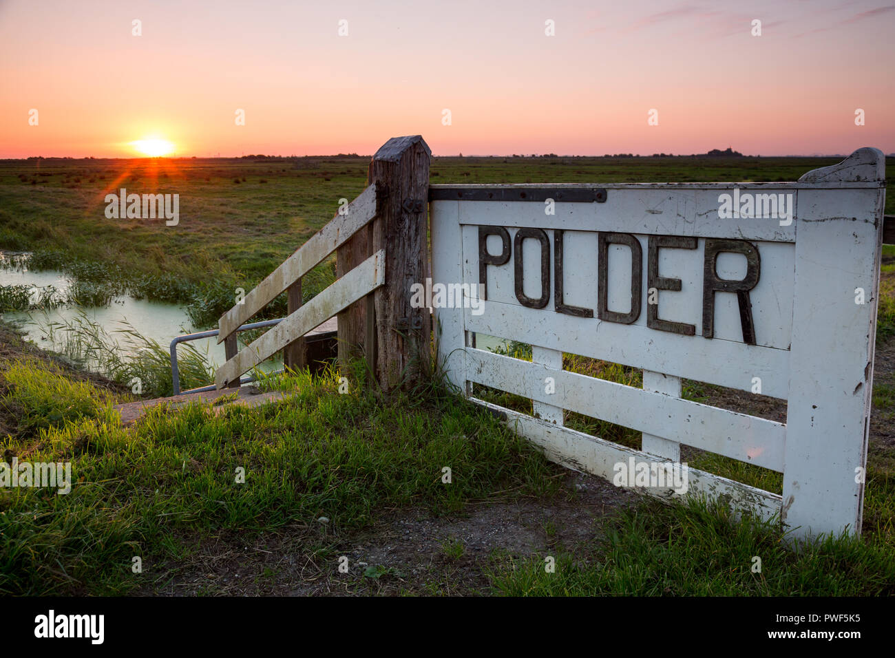 Début de l'aube sur un polder néerlandais, près de Durgerdam, Amsterdam, Pays-Bas. Un signe isolé a mentionné le mot Polder sous un ciel coloré. Pho Banque D'Images