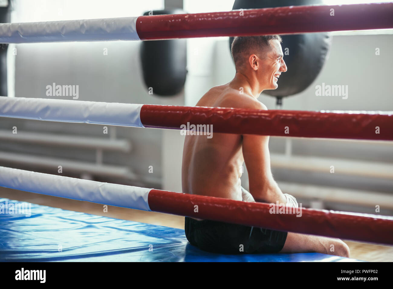 L'homme athlétique repose en anneau et rit. Pause dans le sport. Se détendre avant Boxer lutte Banque D'Images
