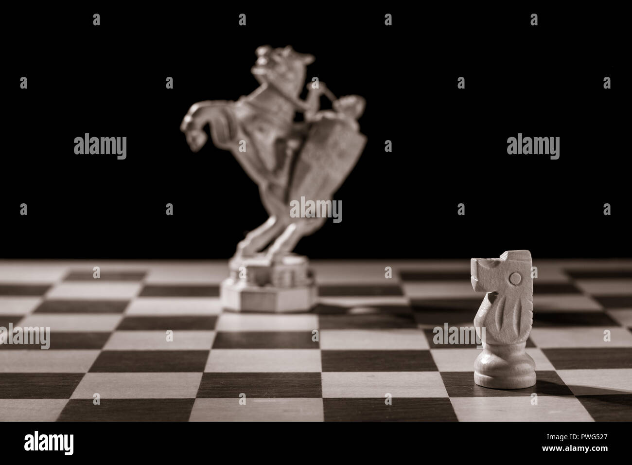 Classic white knight et la même pièce d'échecs sous la forme de la figure médiévale sur l'arrière-plan. Selective focus on classique Banque D'Images