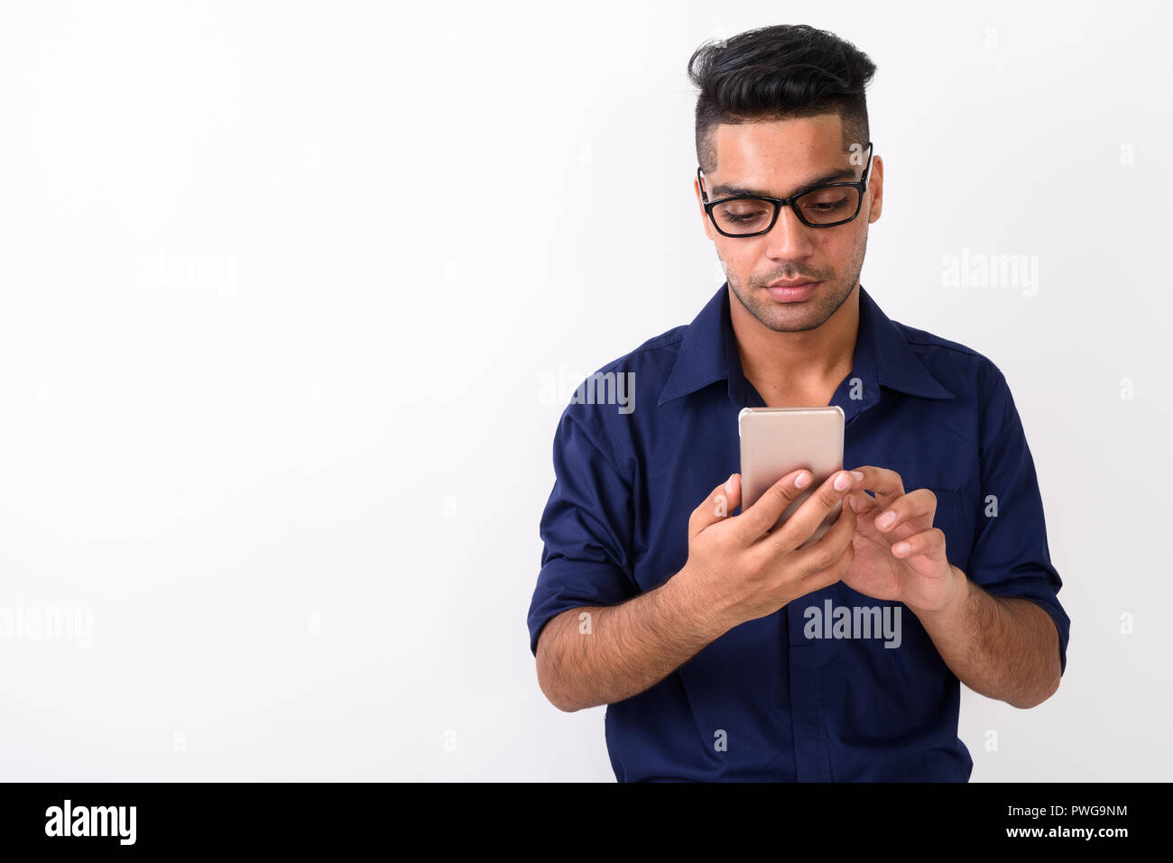 Young Indian businessman using mobile phone contre zone blanche Banque D'Images