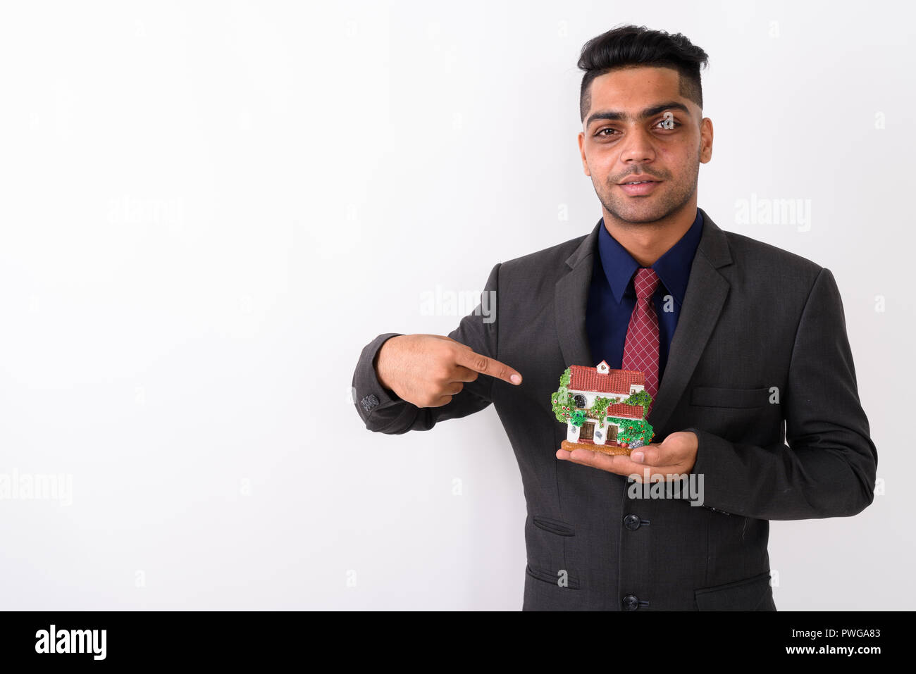 Young Indian businessman wearing suit against white background Banque D'Images