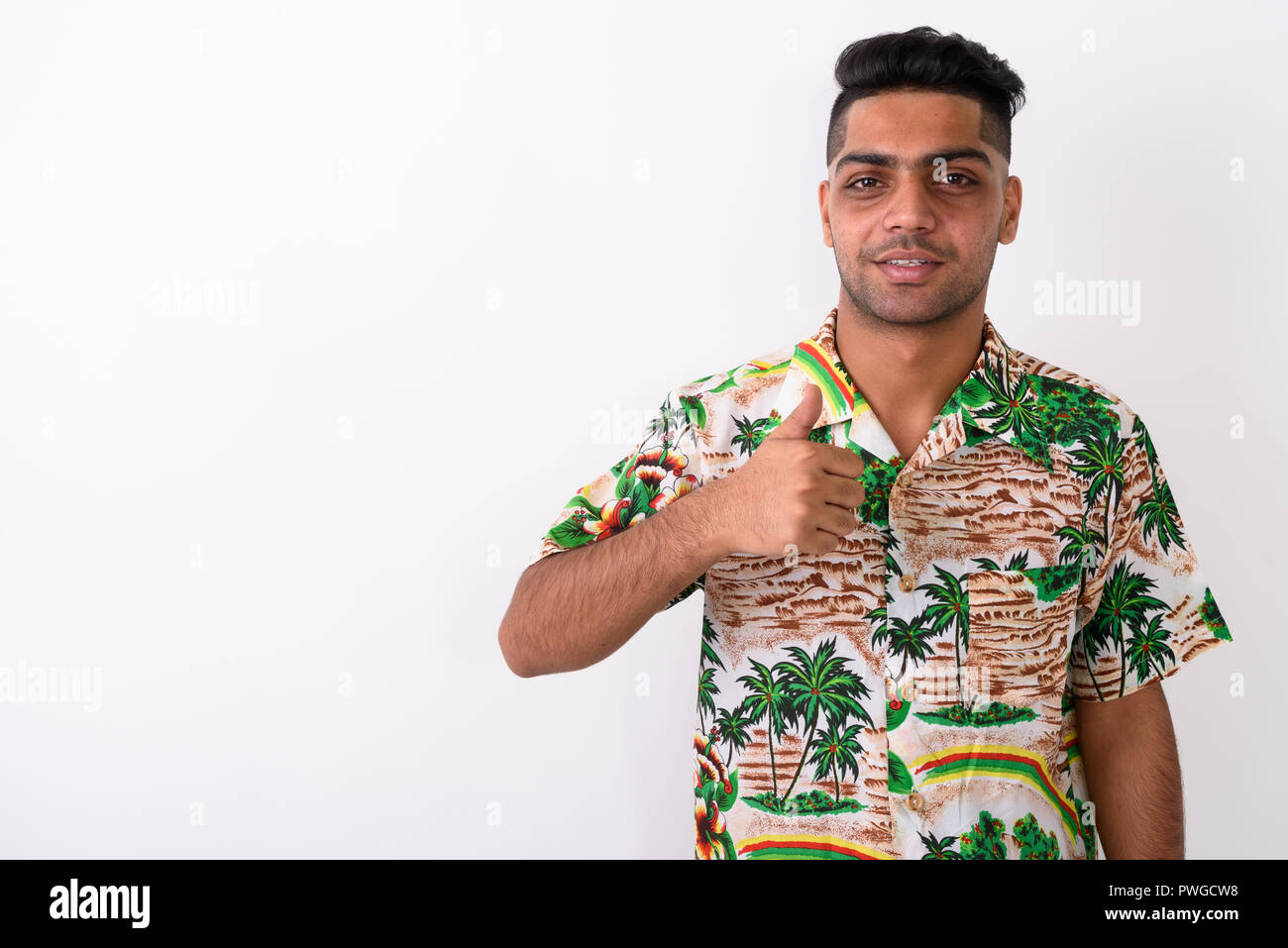 Jeune Indien vêtu d'Hawaiian shirt blanc contre ba Banque D'Images