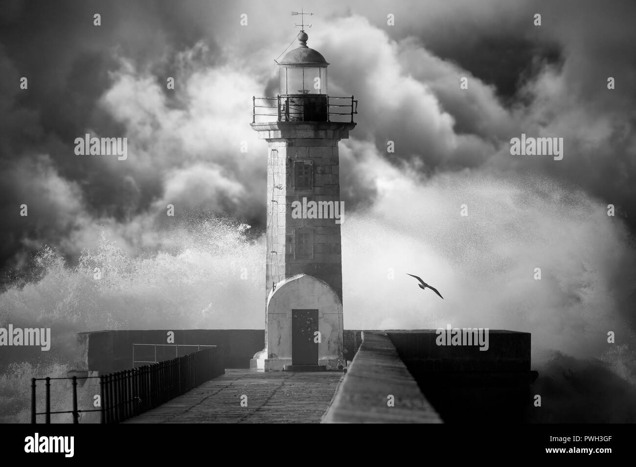 Ancien phare contre un ciel nuageux ciel d'orage. Converti en noir et blanc. Ajouté le bruit numérique. Banque D'Images