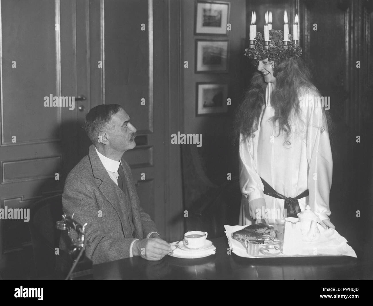 Lucia celebration 1930. Photo Karl Landsteiner , 1868-1943, biologiste Autrichien, médecin, immunologue et. Connu pour avoir développé le système moderne de classification des groupes sanguins. Ici 1930 à Stockholm lorsqu'une jeune femme que Lucia le traite pour le café. Landsteiner a reçu le Prix Nobel de physiologie ou médecine cette année et est à Stockholm pour accepter le prix. Banque D'Images