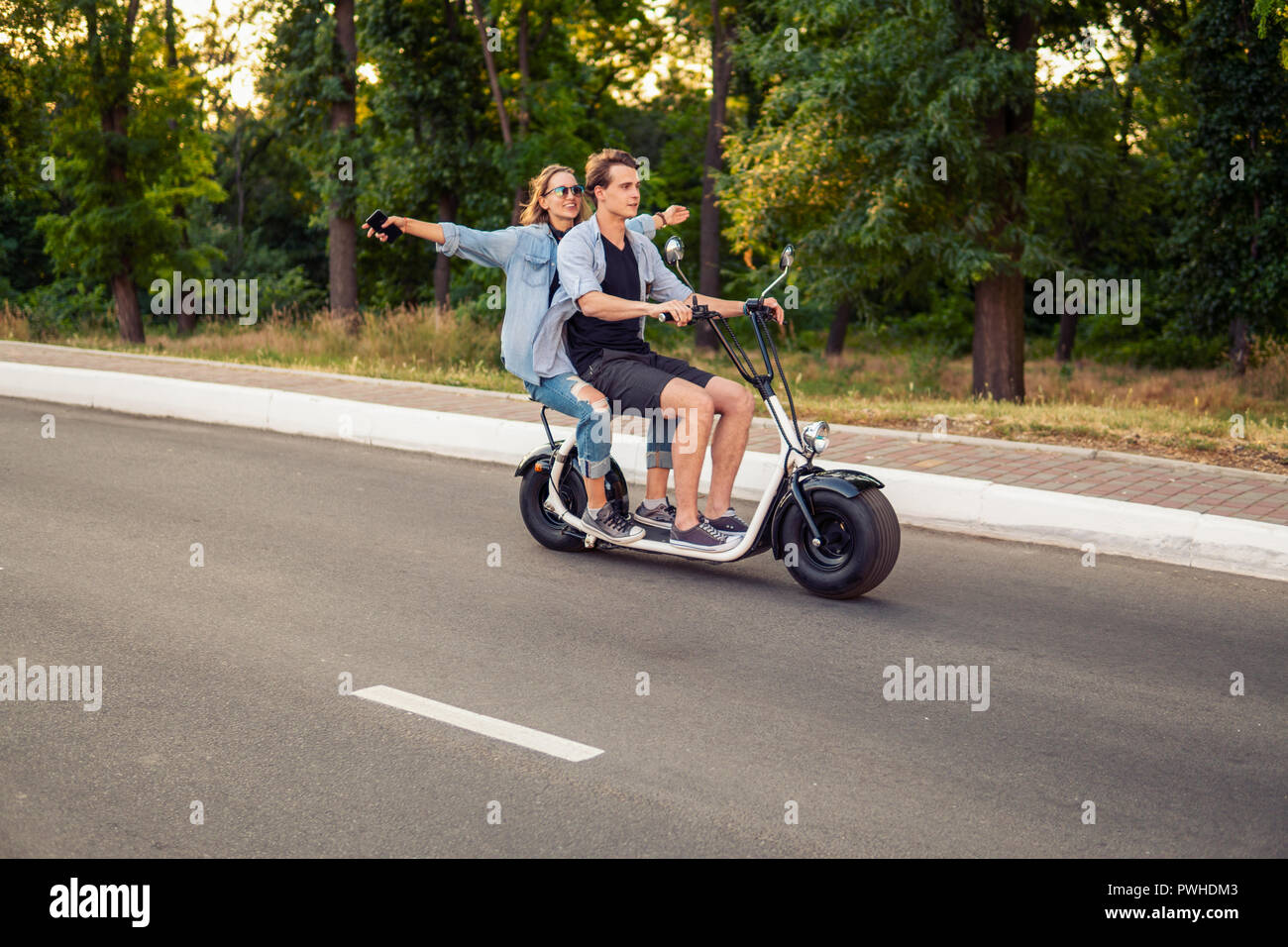 Joli jeune couple roulant vélo électrique en été Banque D'Images