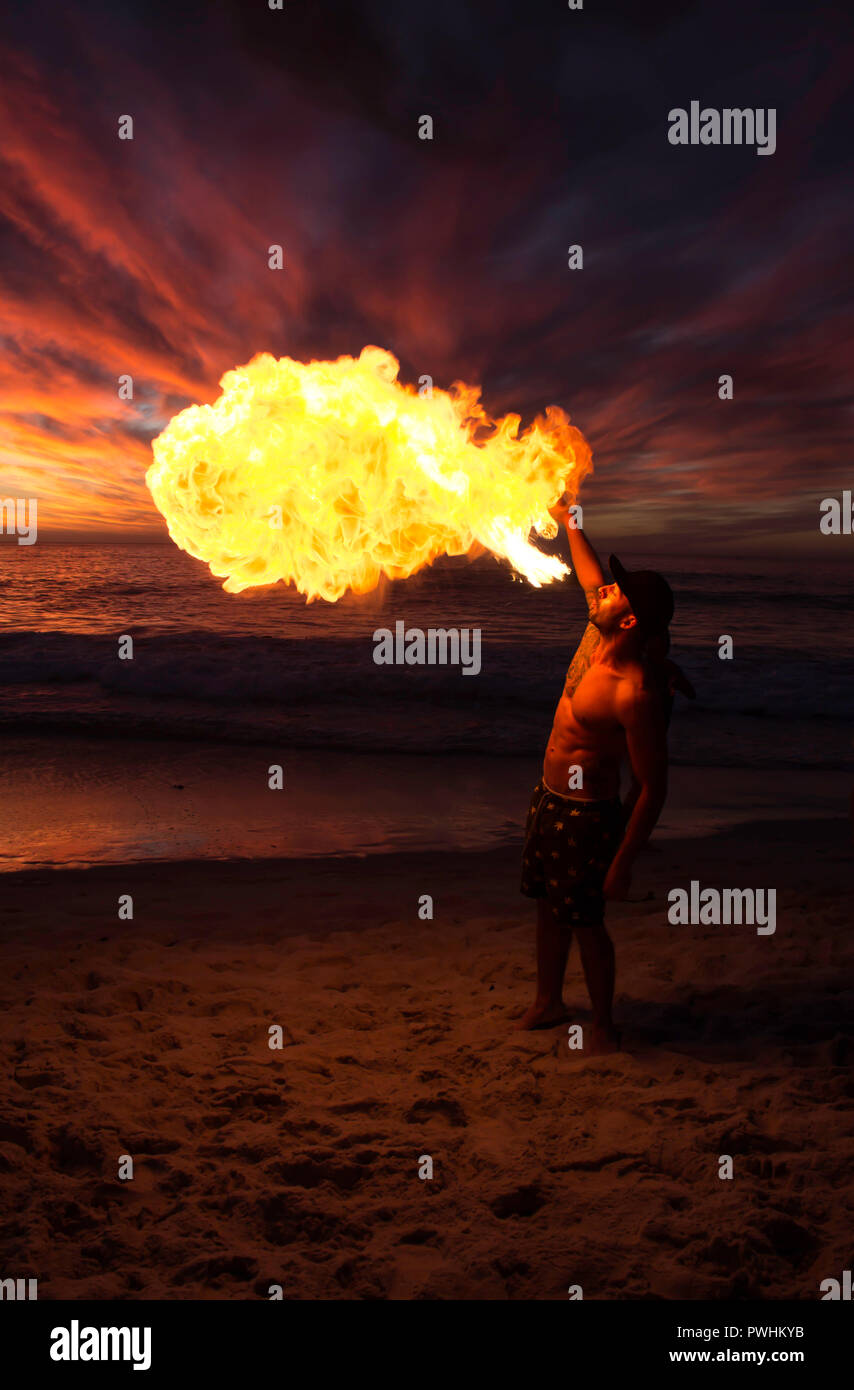 L'homme souffle le feu sur la plage Banque D'Images