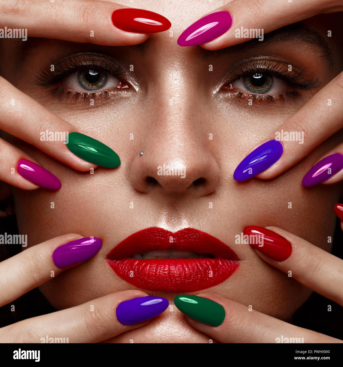 Belle fille avec un make-up classique et multi-couleur des ongles. Conception de manucure. Beauté Visage. Banque D'Images