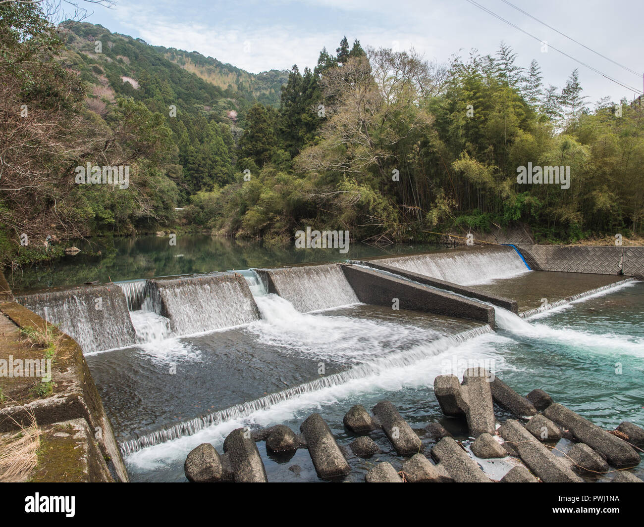 La gestion de la rivière, un barrage de façonner le débit de la rivière, avec au-dessous les tétrapodes, Iyoki River, Koch, Shikoku, Japon Banque D'Images