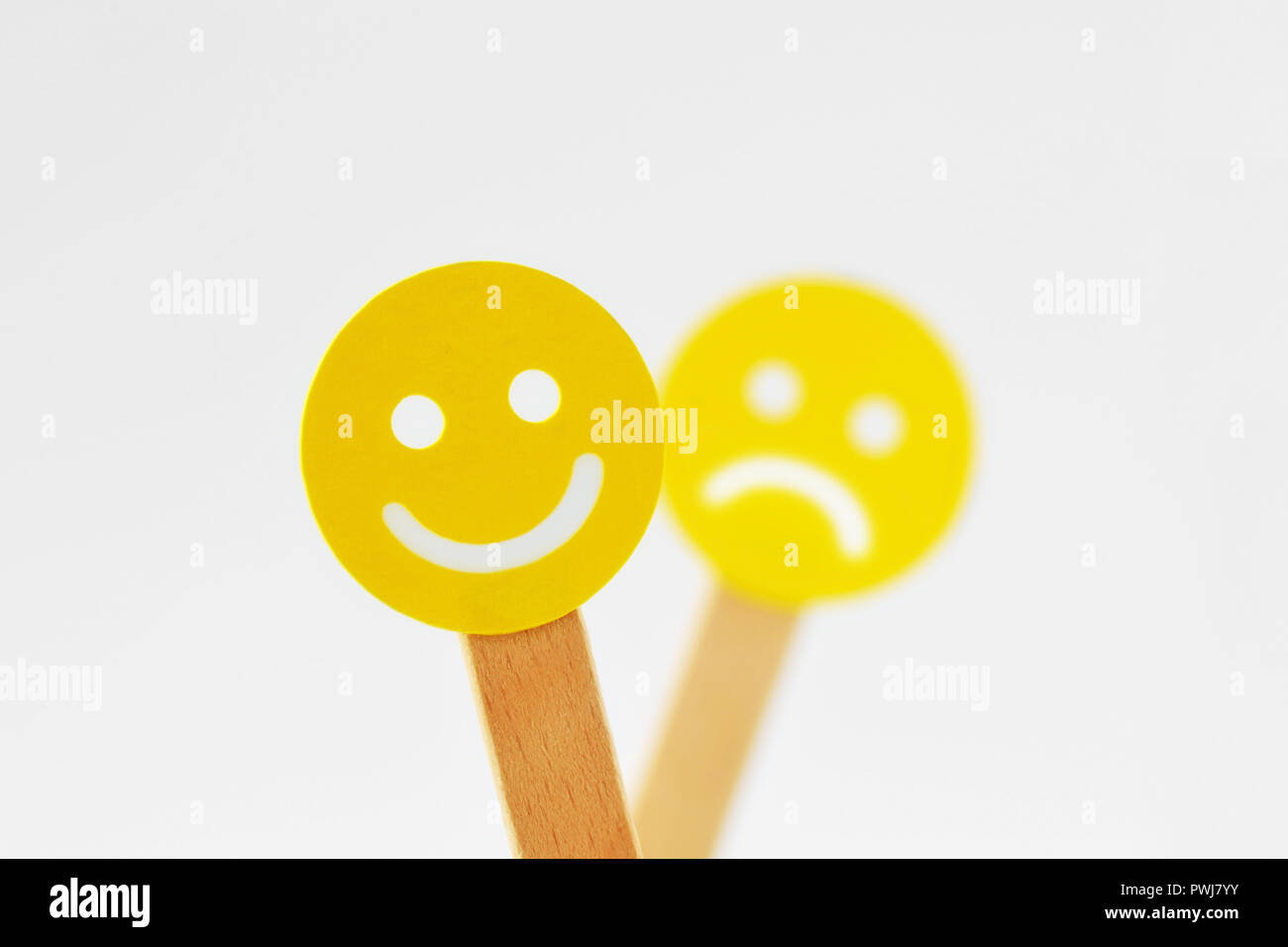 Smiley face à l'expression positive en face de l'foucs visage triste - Notion de positivité Banque D'Images