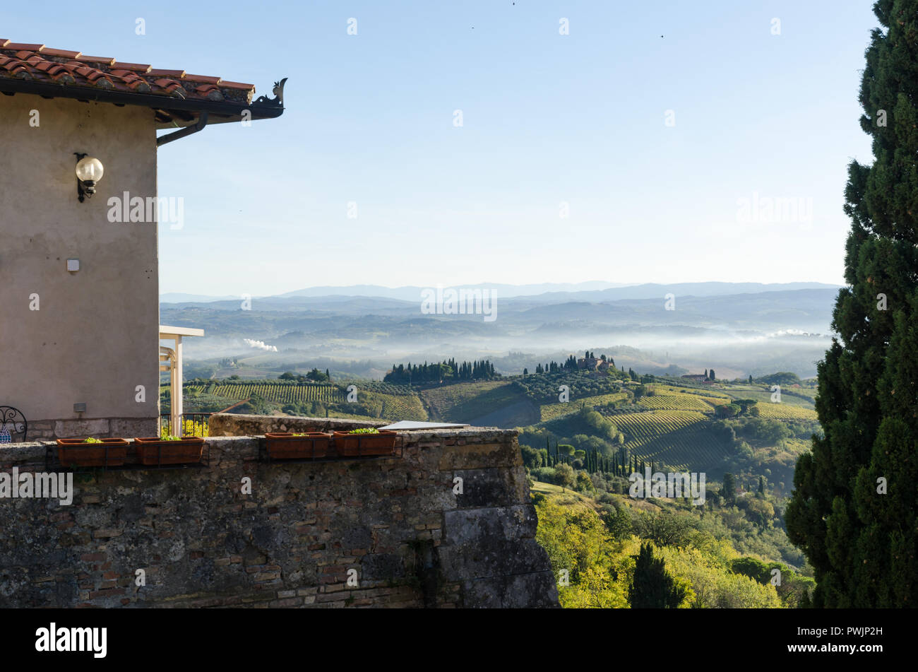 Brume du matin par les collines au village San Gimignano en Toscane, Italie Banque D'Images