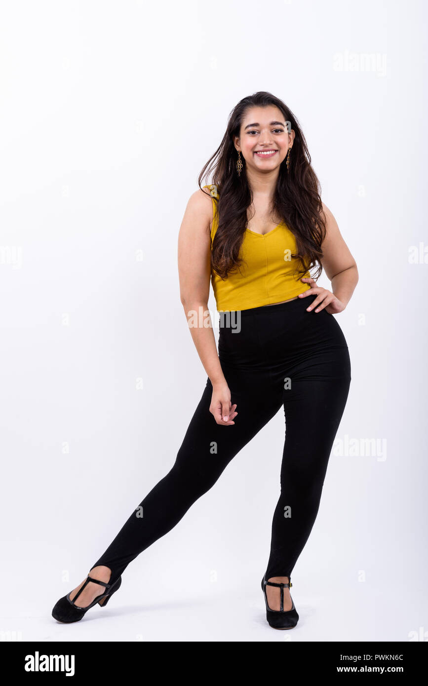 Full body shot of young happy Indian woman smiling tout en se posant Banque D'Images