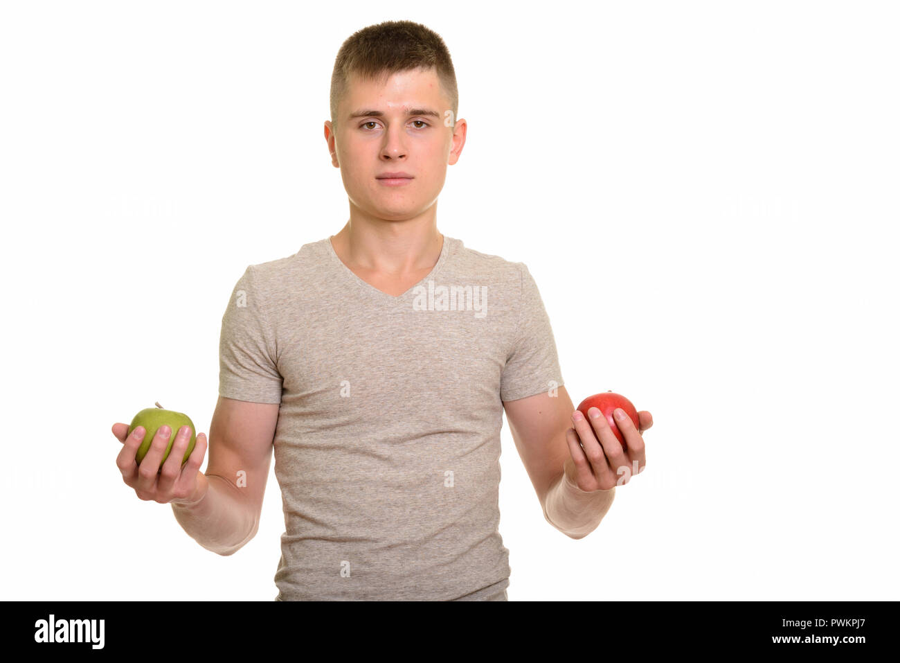 Young man holding red et green apple Banque D'Images