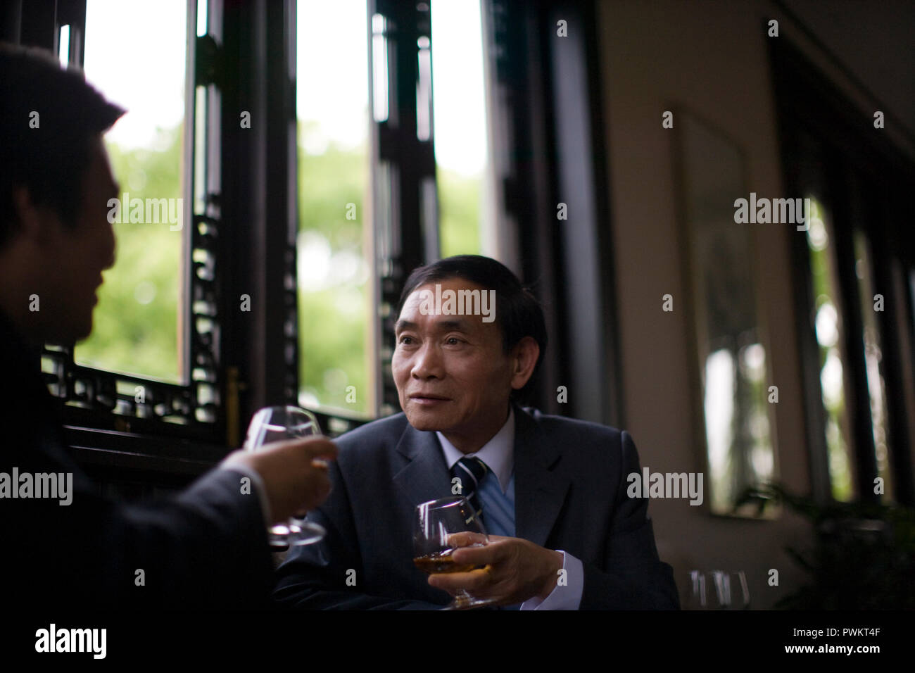 Deux hommes d'affaires de boire du vin rouge au cours d'une discussion. Banque D'Images