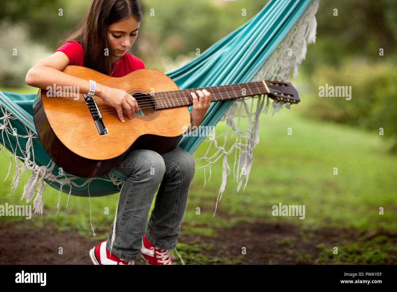 Jeune fille qui joue de la guitare sur un hamac dans le pays Photo Stock -  Alamy